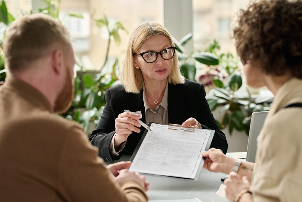 Portrait,Of,Mature,Woman,Handing,Contract,Forms,To,Couple,In Mediation Consulting + Coaching